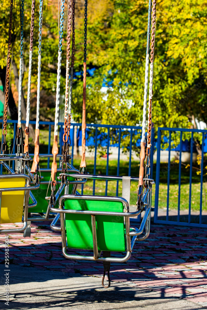 Empty carousel metal seat. Amusement park concept in a city park. Sunny day. Empty carousel metal seat. Amusement park concept in a city park. Sunny day.