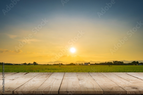 Fototapeta Naklejka Na Ścianę i Meble -  Rice field sunset and Empty wood table for product display and montage.