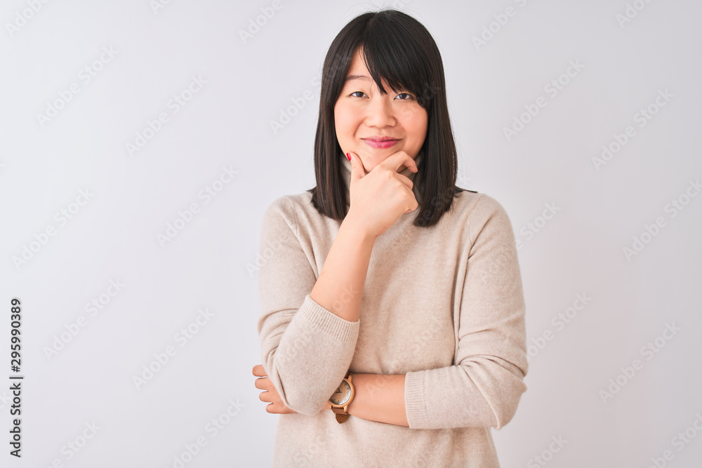Young beautiful chinese woman wearing turtleneck sweater over isolated white background looking confident at the camera with smile with crossed arms and hand raised on chin. Thinking positive. Young beautiful chinese woman wearing turtleneck sweater over isolated white background looking confident at the camera with smile with crossed arms and hand raised on chin. Thinking positive.
