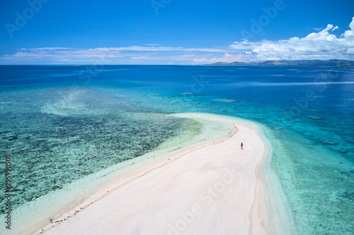 Woman on remote island in Fiji overlooking blue coral reef	 photo