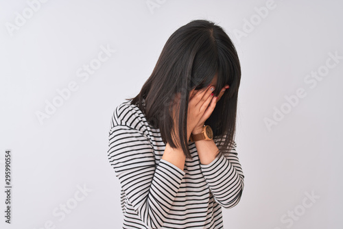 Young beautiful chinese woman wearing black striped t-shirt over isolated white background with sad expression covering face with hands while crying. Depression concept.