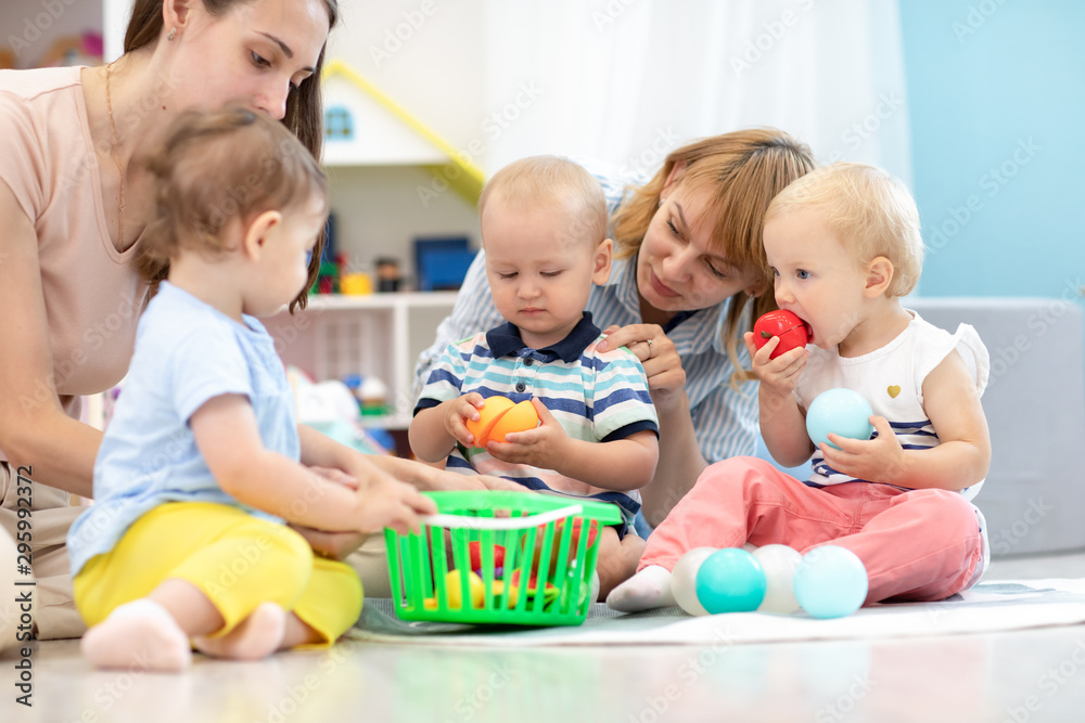 Adorable babies toddlers playing at home or kindergarten, cutting plastic vegetables and tasting these toys. Games in creche Adorable babies toddlers playing at home or kindergarten, cutting plastic vegetables and tasting these toys. Games in creche