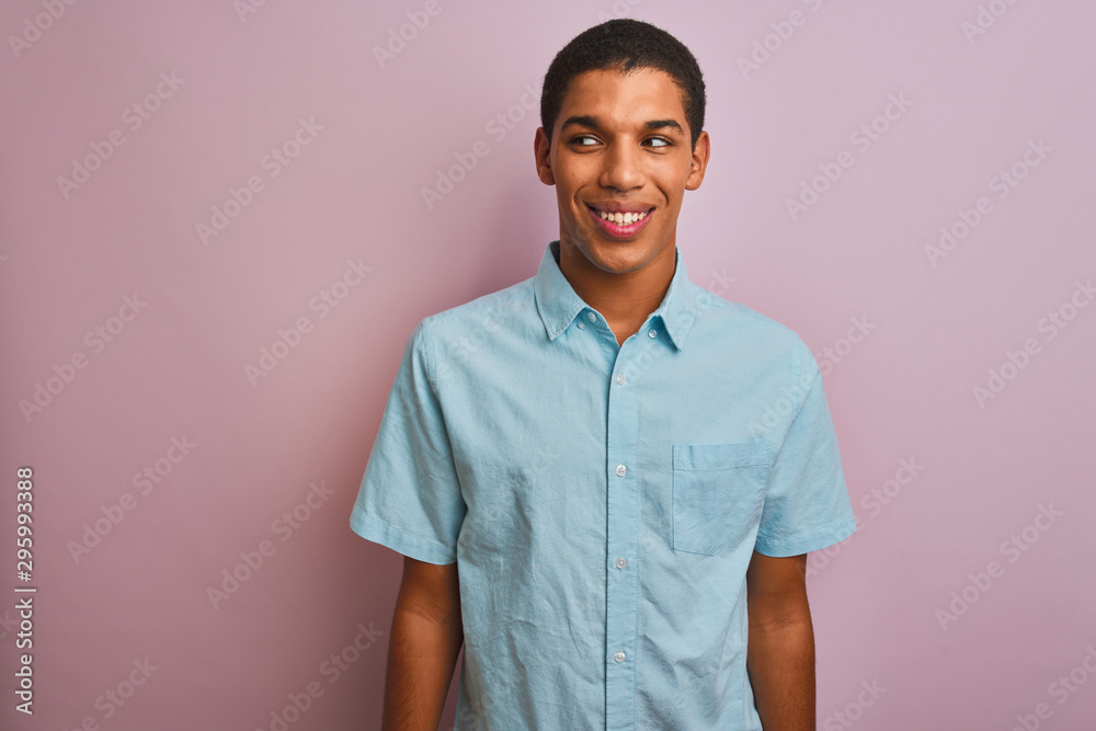 Young handsome arab man wearing blue shirt standing over isolated pink background smiling looking to the side and staring away thinking. Young handsome arab man wearing blue shirt standing over isolated pink background smiling looking to the side and staring away thinking.