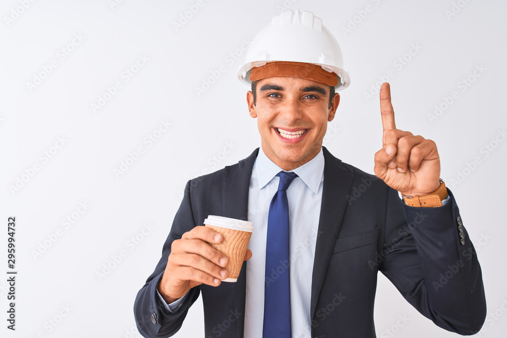 Young handsome architect man wearing helmet drinking coffee over isolated white background surprised with an idea or question pointing finger with happy face, number one Young handsome architect man wearing helmet drinking coffee over isolated white background surprised with an idea or question pointing finger with happy face, number one