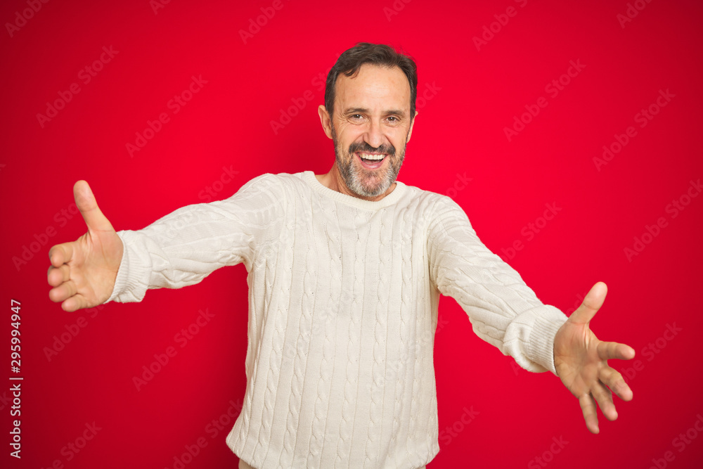 Handsome middle age senior man with grey hair over isolated red background looking at the camera smiling with open arms for hug. Cheerful expression embracing happiness. Handsome middle age senior man with grey hair over isolated red background looking at the camera smiling with open arms for hug. Cheerful expression embracing happiness.