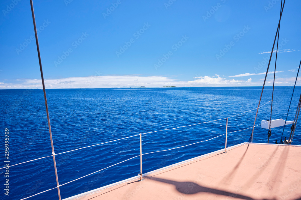 Sailing through small island in Fiji with bright blue sky and smooth waters