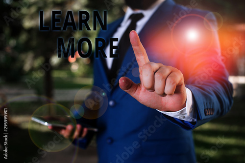 Word writing text Learn More. Business photo showcasing knowledge or skill acquired by instruction Considerable learning Businessman with pointing finger in front of him photo