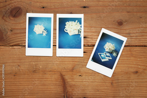 three instant photo of white flower on wood background, picture in picture