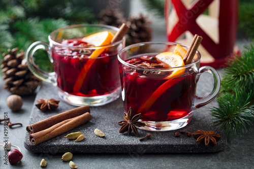 Mulled red wine with spices. Christmas decoration. Grey stone background. Close up.