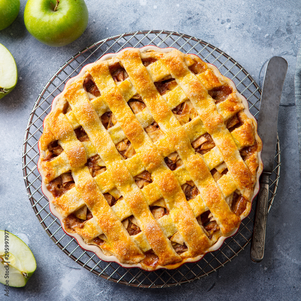 Apple pie on a cooling rack. Grey background. Close up. Top view. Apple pie on a cooling rack. Grey background. Close up. Top view.