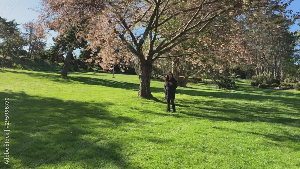 Following lady walking through park on a cold sunny day Following lady walking through park on a cold sunny day