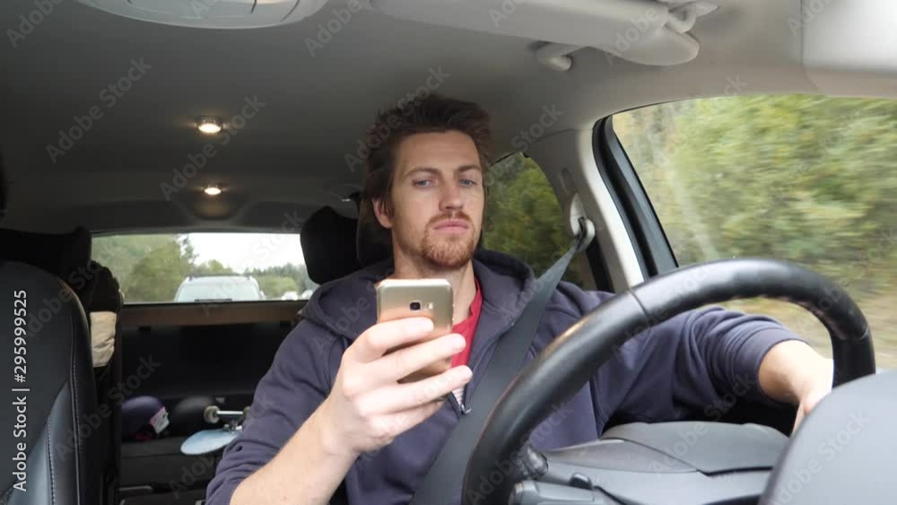 Man dangerously texts on his smartphone as he drives distracted