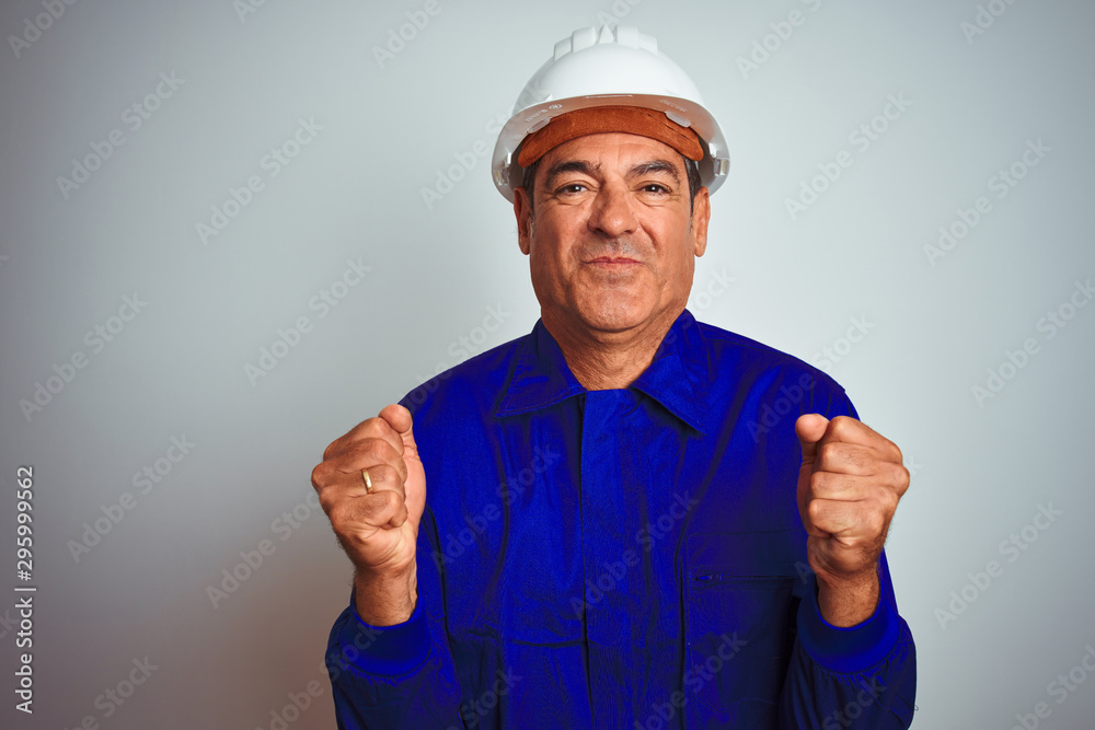 Handsome middle age worker man wearing uniform and helmet over isolated white background excited for success with arms raised and eyes closed celebrating victory smiling. Winner concept. Handsome middle age worker man wearing uniform and helmet over isolated white background excited for success with arms raised and eyes closed celebrating victory smiling. Winner concept.