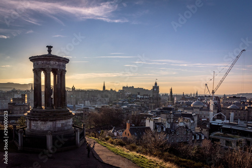 EDINBURGH, SCOTLAND DECEMBER 14, 2018: Beautiful sunset at the Dugald Stewart Monument in the foreground with central Edinburgh cityscape behind including Edinburgh Castle and North Bridge © Andres Conema