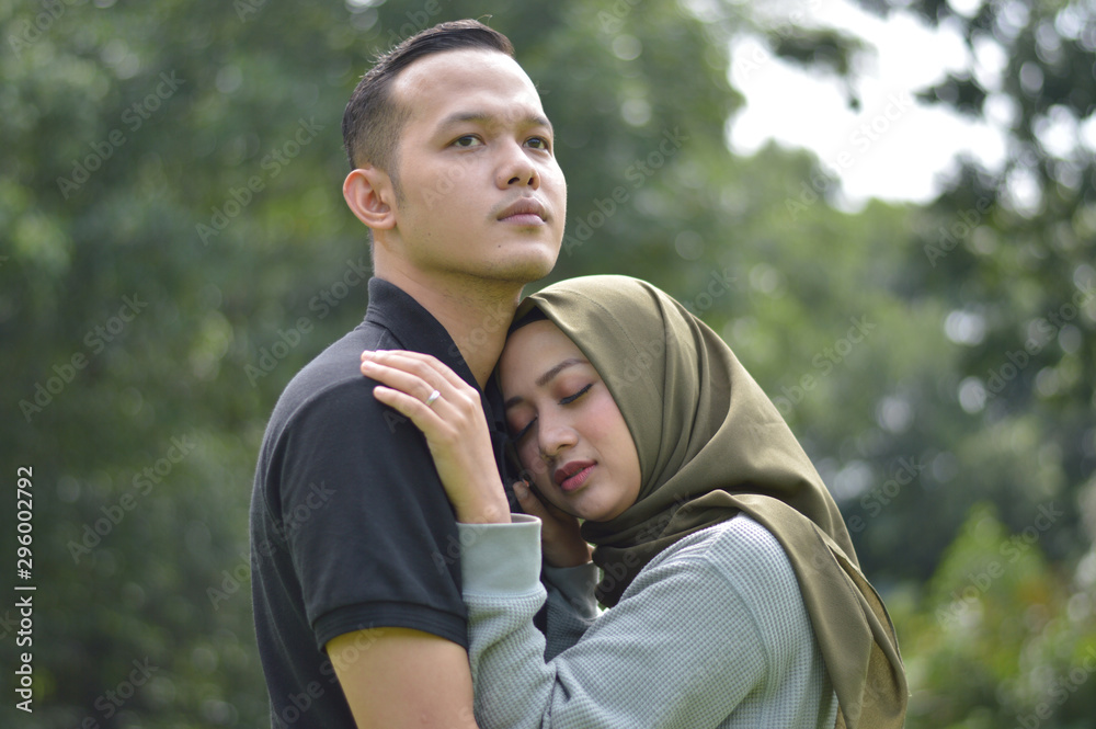 lovely asian Muslim young couple embracing at outdoors lovely asian Muslim young couple embracing at outdoors