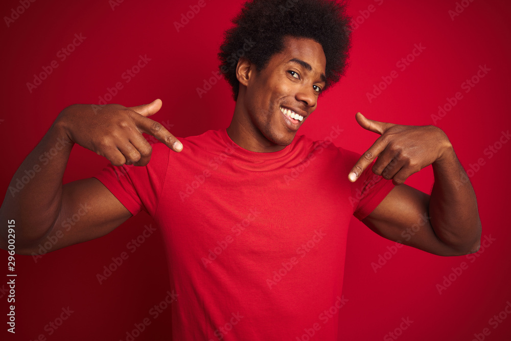 Young american man with afro hair wearing t-shirt standing over isolated red background looking confident with smile on face, pointing oneself with fingers proud and happy. Young american man with afro hair wearing t-shirt standing over isolated red background looking confident with smile on face, pointing oneself with fingers proud and happy.