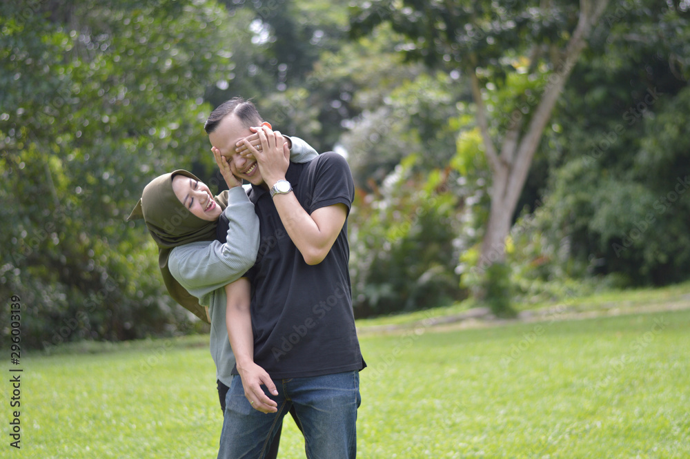 Happy Muslim young couple of lovers enjoy life moments. Hijab woman covering her boyfriend eyes to surpised Handsome man spending time together Happy Muslim young couple of lovers enjoy life moments. Hijab woman covering her boyfriend eyes to surpised Handsome man spending time together