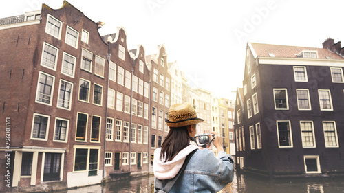 Outdoor lifestyle portrait of pretty young woman having fun in the city in Europe with digital camera travel photo of photographer Making pictures in hipster style © PORNCHAI SODA