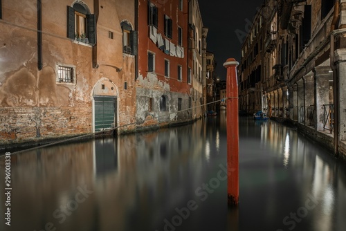 Horizontal shot of a canal between the old buildings in Venice, Italy during nighttime