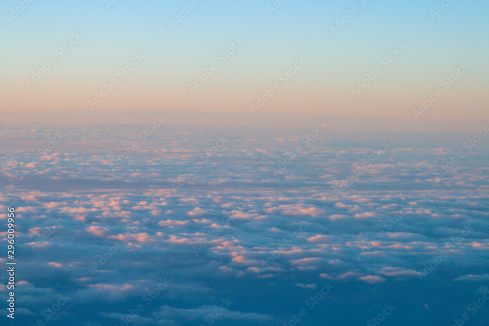 Un mar de nubes con los colores cálidos del atardecer. Fotografía desde un avión. Un mar de nubes con los colores cálidos del atardecer. Fotografía desde un avión.