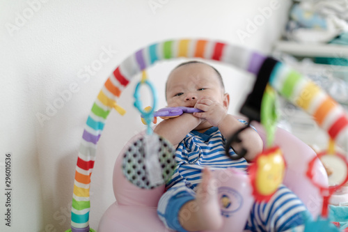 Baby with toy in mouth on play gym