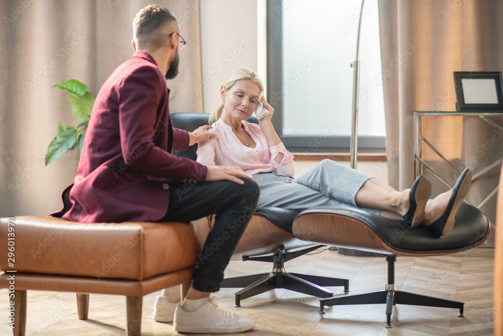 Obraz premium Psychoanalyst touching shoulder of client while supporting her