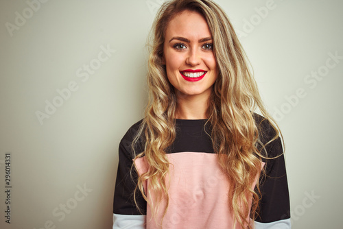 Young attractive woman wearing sweatshirt standing over white isolated background with a happy and cool smile on face. Lucky person.