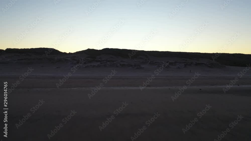 Flying up to sand hill and dune, lifting up and revealing a golden horizon Flying up to sand hill and dune, lifting up and revealing a golden horizon