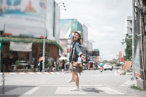 Smiling woman traveler in thapae gate landmark chiangmai thailand with backpack holding world map on holiday, relaxation concept, travel concept © I Believe I Can Fly