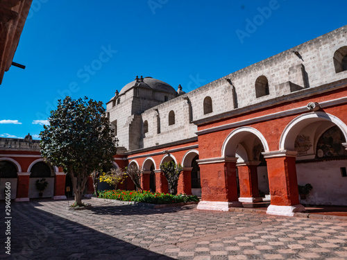 Inner courtyard in Saint Catherine Monastery, Arequipa city, Peru. Contrast of the tree surrounded by white walls of the monastery and the red walls that was the place where the nuns lived