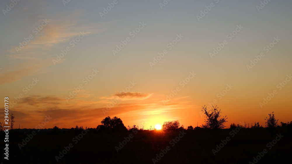 Happy new day concept: summer sunrise over beautiful field and stunning sky