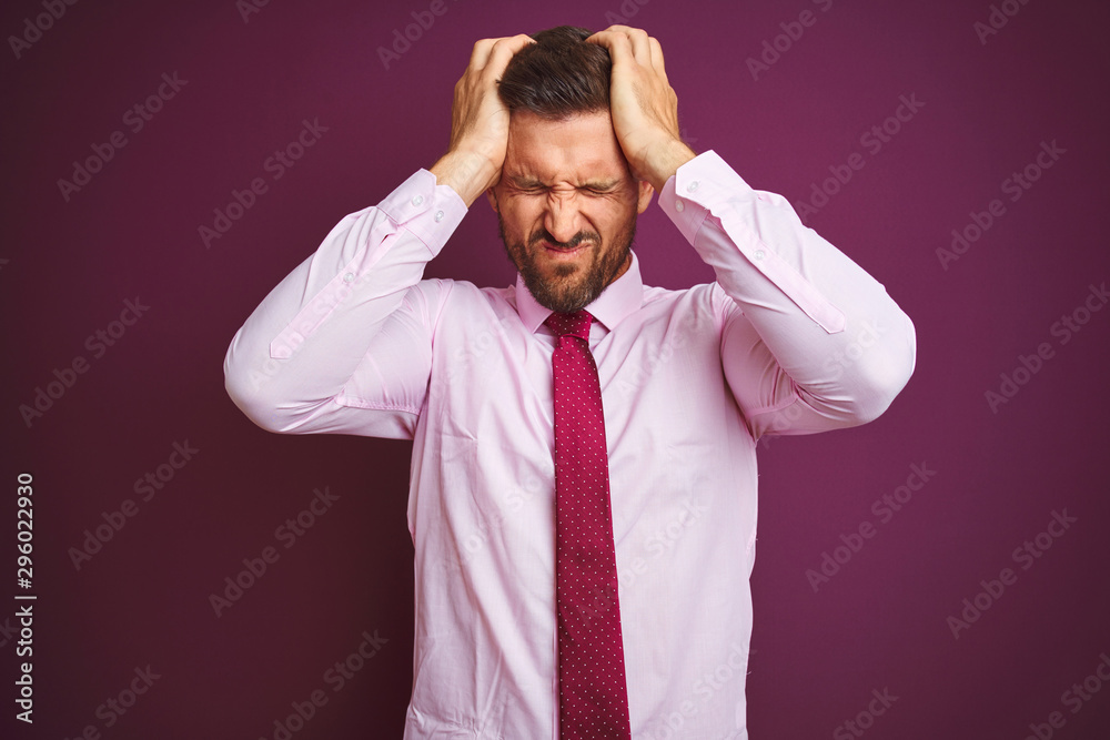 Young business man wearing elegant shirt and tie over purple isolated background suffering from headache desperate and stressed because pain and migraine. Hands on head. Young business man wearing elegant shirt and tie over purple isolated background suffering from headache desperate and stressed because pain and migraine. Hands on head.