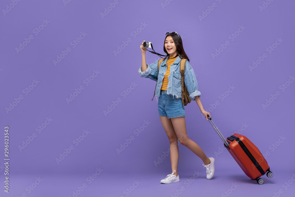 Smiling Asian tourist girl with camera and baggage Smiling Asian tourist girl with camera and baggage