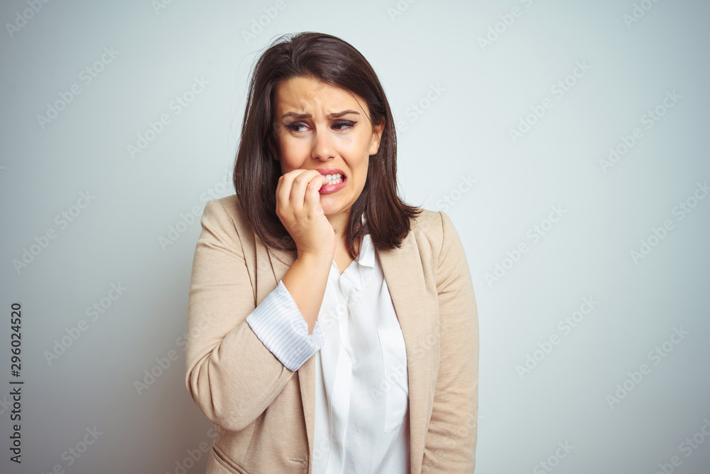 Young beautiful elegant business woman over isolated background looking stressed and nervous with hands on mouth biting nails. Anxiety problem. Young beautiful elegant business woman over isolated background looking stressed and nervous with hands on mouth biting nails. Anxiety problem.