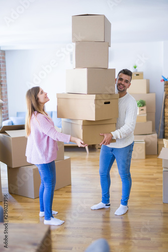 Young couple moving to a new house holding cardboard boxes worried about falling for overweight