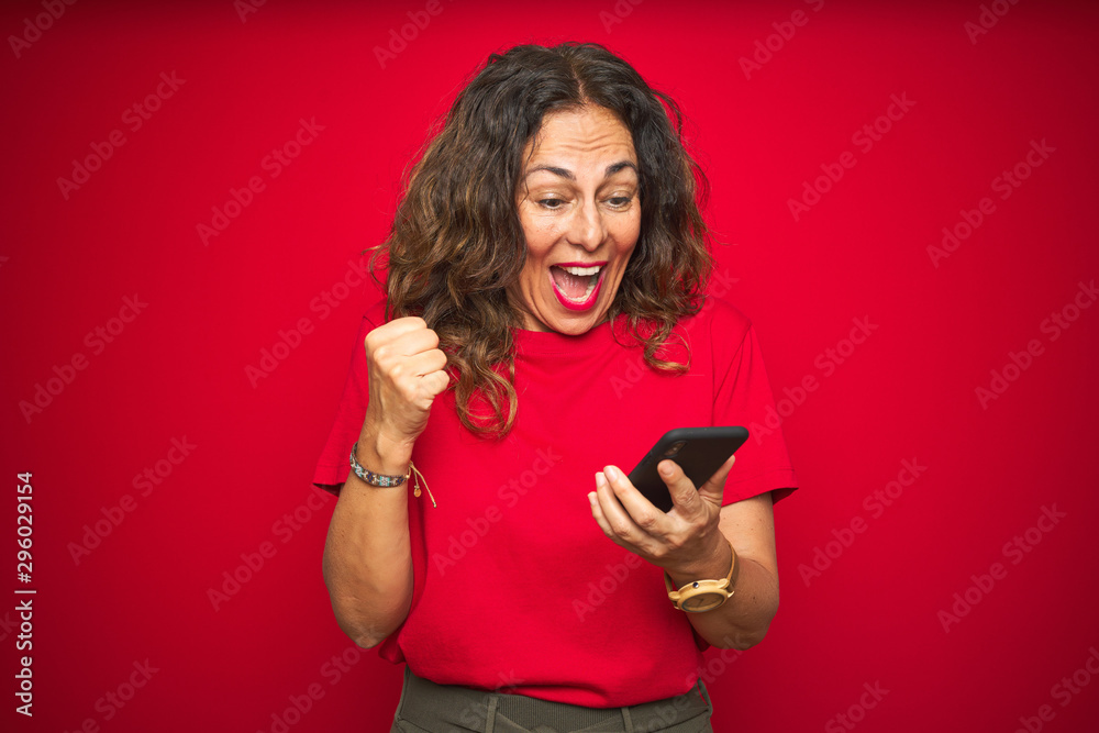 Middle age senior woman using smartphone over red isolated background screaming proud and celebrating victory and success very excited, cheering emotion Middle age senior woman using smartphone over red isolated background screaming proud and celebrating victory and success very excited, cheering emotion
