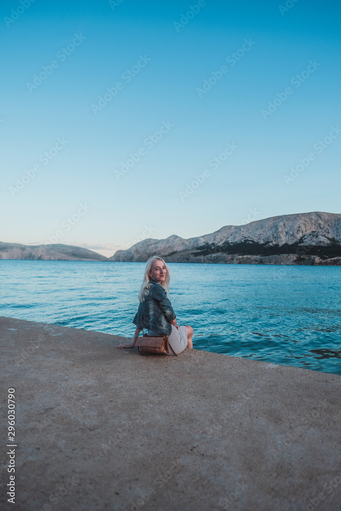 young woman on the beach by the sea with mountain view