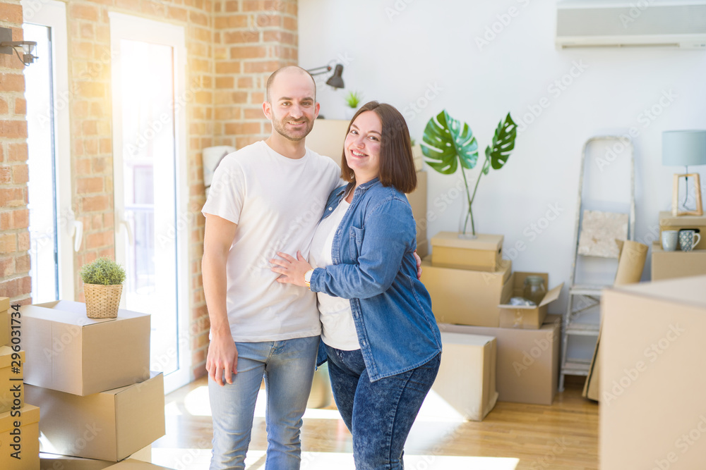 Young couple together smiling happy moving to a new house Young couple together smiling happy moving to a new house