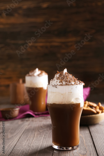 Glass of tasty frappe coffee on wooden table