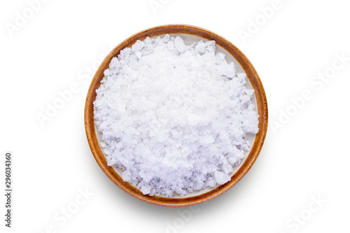 Closeup coarse or rock natural sea salt in brown bowl isolated on white background. Clipping path. Top view.