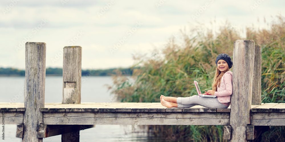 glückliches Kind am See mit Laptop glückliches Kind am See mit Laptop