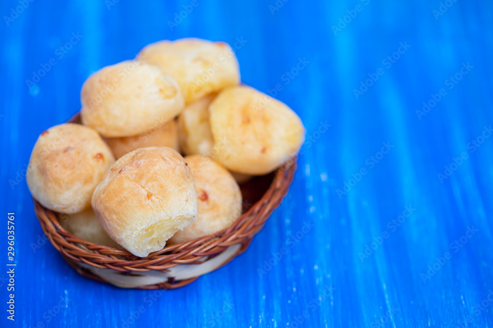 typical brazilian cheese bread in dish on blue wooden background typical brazilian cheese bread in dish on blue wooden background