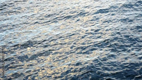 The surface of the water in slow motion. The video was shot at sunset and you can see the reflection of the sun from the water.