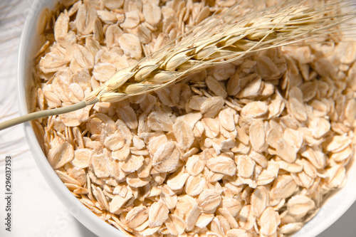 ear of wheat close-up on a background of oatmeal in a plate. natural nutrition