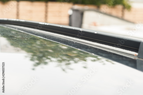 Roof rails on the car. Flaking paint. Corrosion.