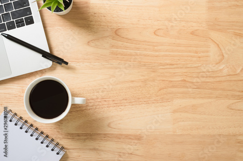 Flay lay, Top view office table desk with laptop computer, keyboard, coffee, pen and green plant with copy space background.