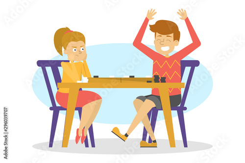 Children sitting at the table and play checkers. Board game