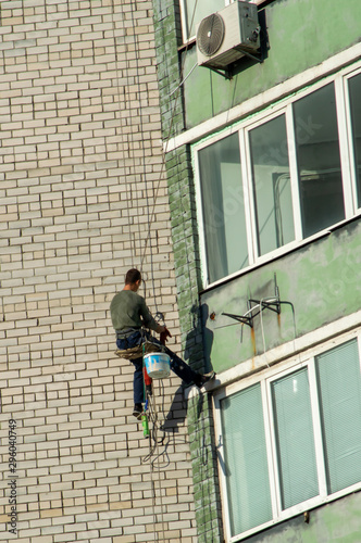 Wallpaper Mural Industrial climber seals cracks in the wall of a building Torontodigital.ca