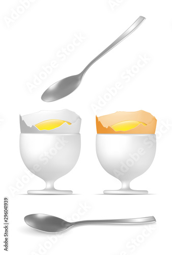 Yellow and white boiled eggs with spoon and egg cups