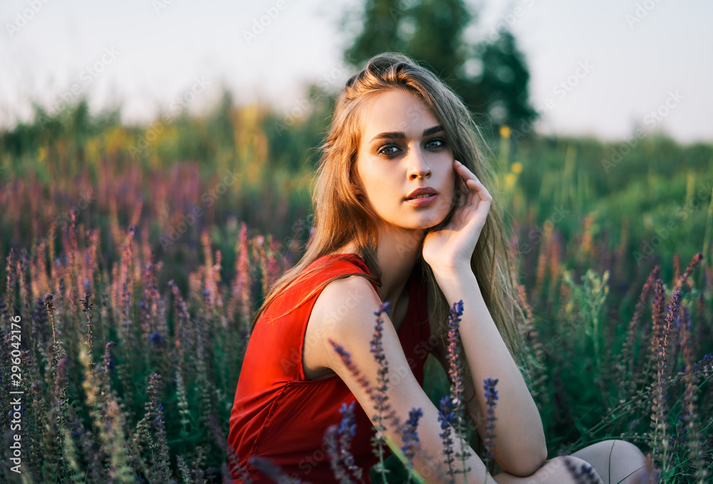 Portrait of beautiful young woman posing in sage field in summer sun